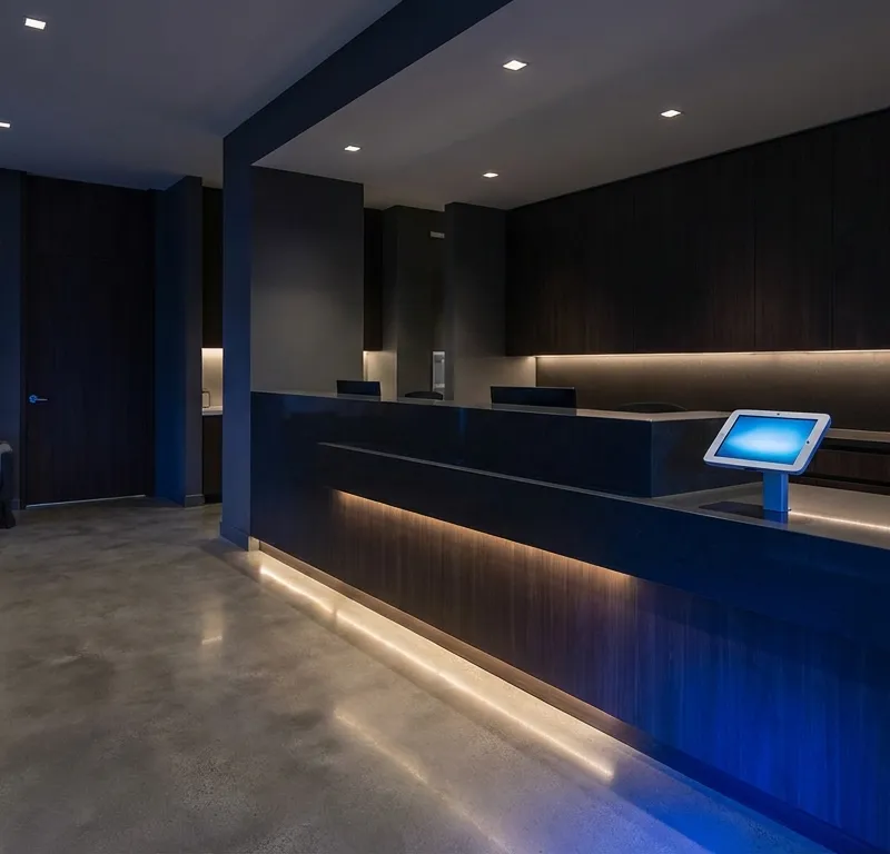 Modern medical office reception with patient checking in on tablet - representing patient acquisition through digital marketing